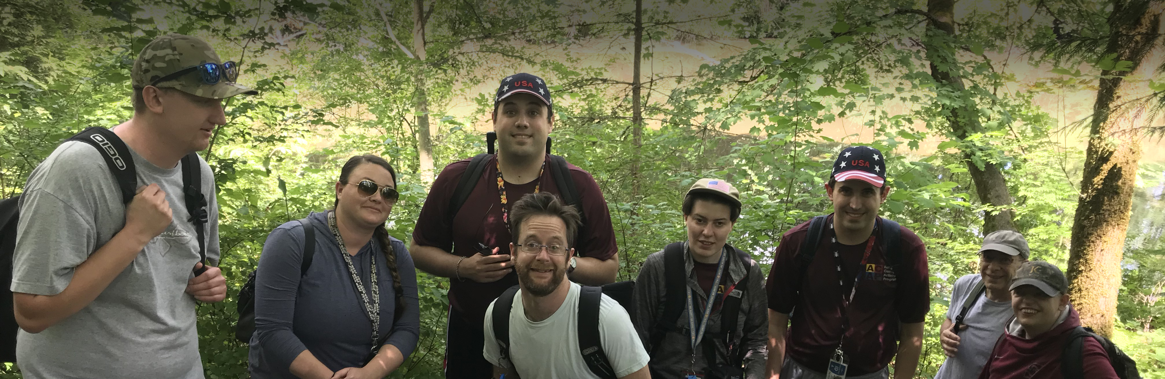 A group of ACAP campers and staff posing in a forest