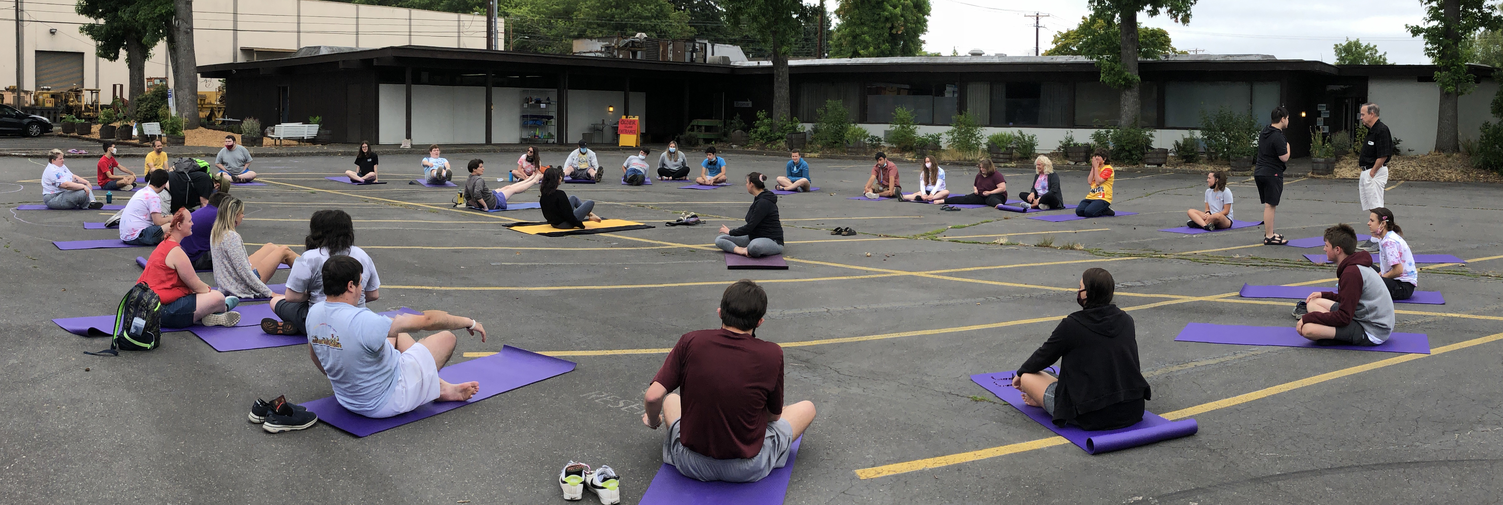 Campers sitting on yoga mats in the ACAP parking lot.