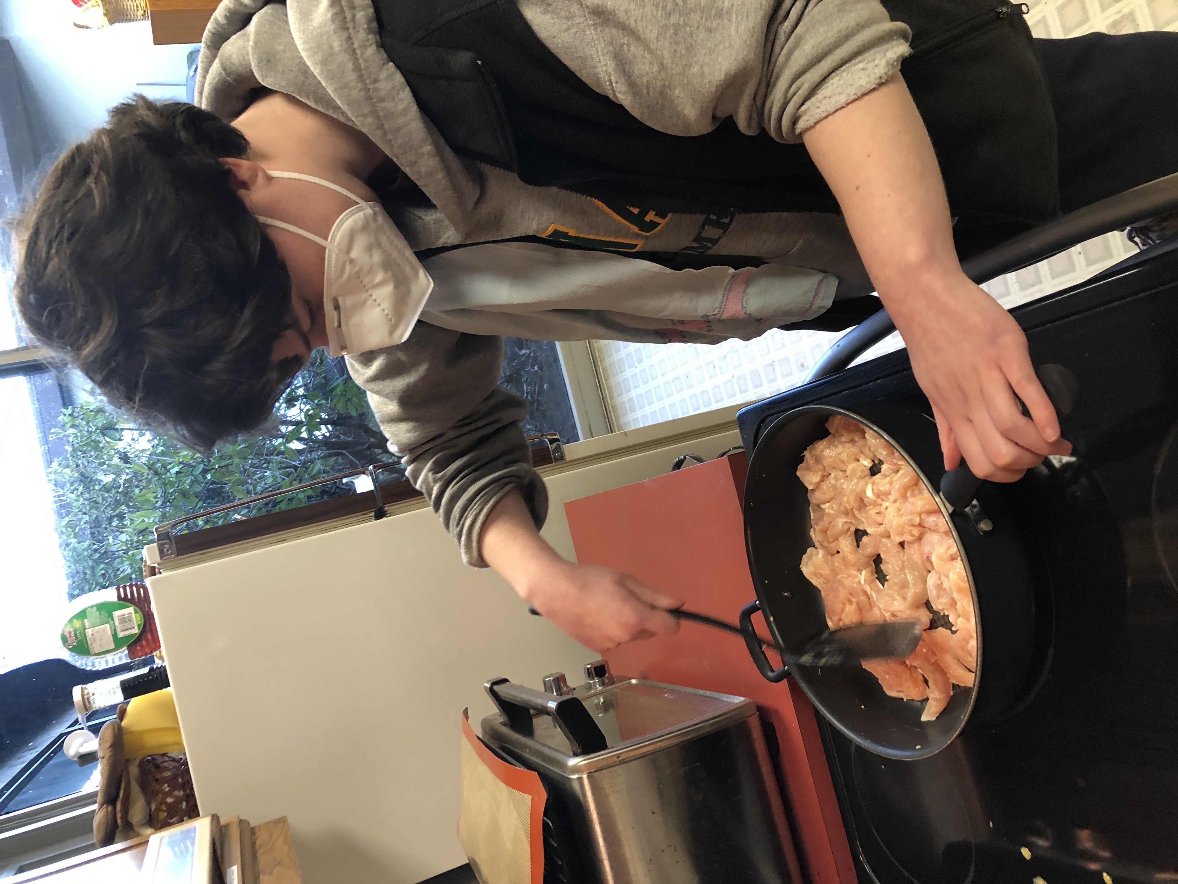 A mentor cooking at a stove.